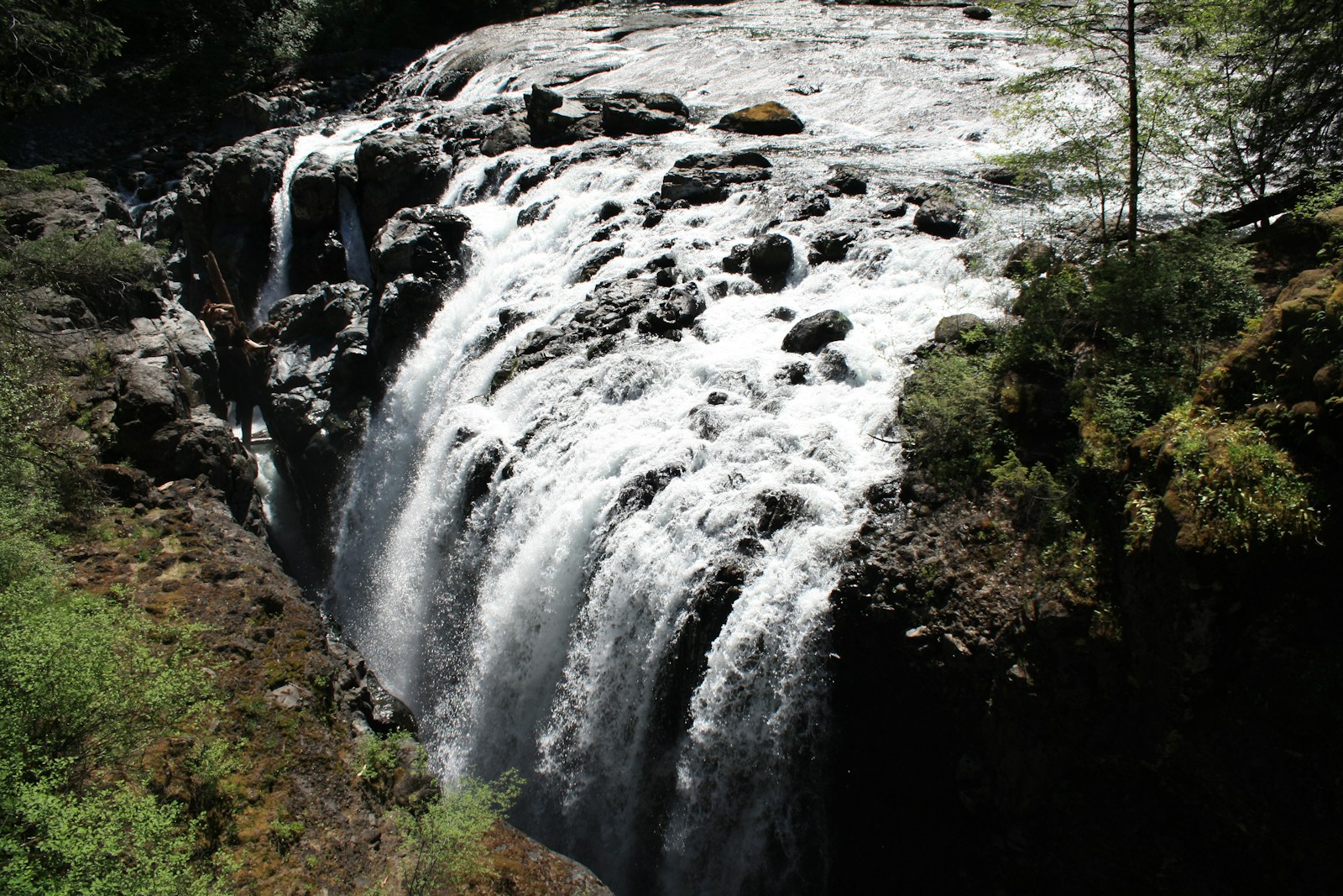 water falls on brown rocky mountain during daytime