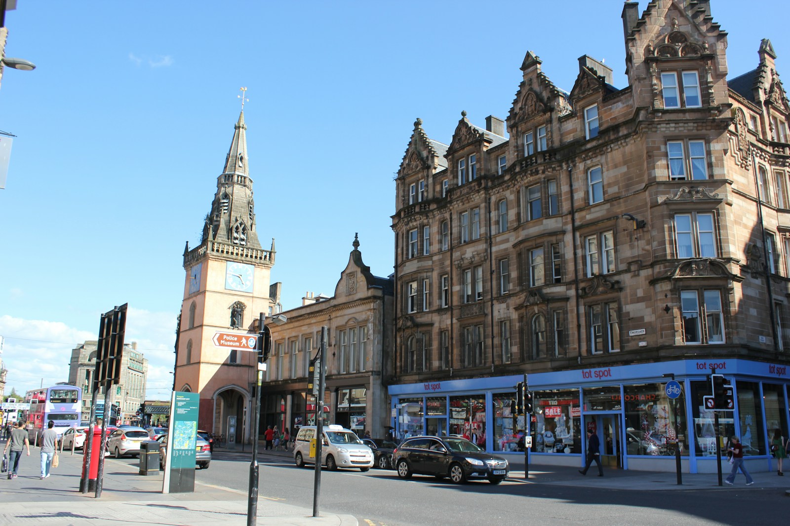 a city street with tall buildings and a clock tower