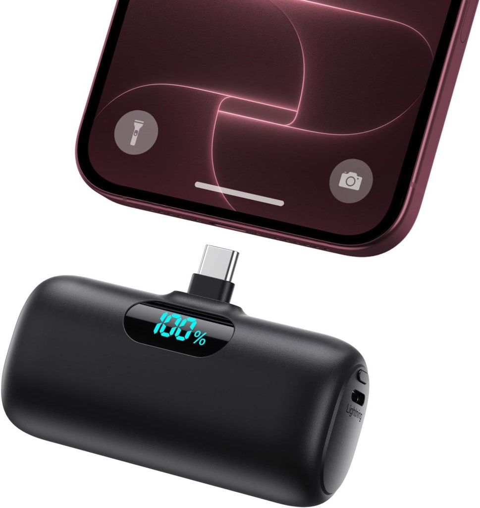 Mini portable phone charger plugged into an iPhone, showing its battery display